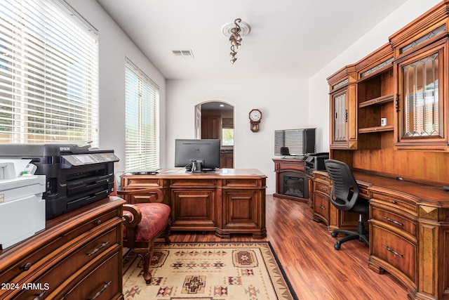 office space featuring a fireplace and dark wood-type flooring