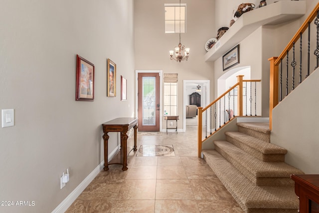 foyer entrance featuring a chandelier and a towering ceiling