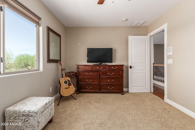 sitting room with light colored carpet, ceiling fan, and a healthy amount of sunlight