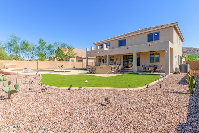 back of property featuring ceiling fan, area for grilling, cooling unit, a patio area, and a bar