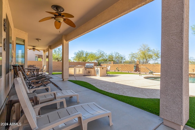 view of patio featuring a fenced in pool, ceiling fan, and exterior kitchen