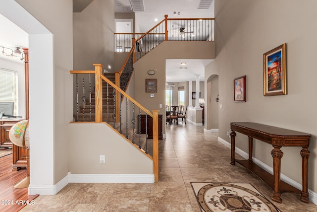 foyer entrance with hardwood / wood-style flooring and a towering ceiling