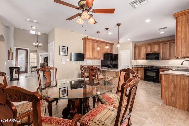 dining space with ceiling fan with notable chandelier, light tile patterned floors, and sink