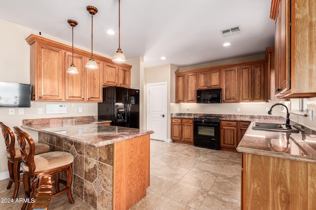 kitchen with black appliances, sink, decorative light fixtures, a kitchen bar, and kitchen peninsula