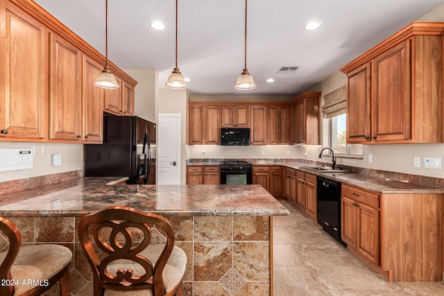 kitchen featuring kitchen peninsula, a kitchen breakfast bar, sink, black appliances, and pendant lighting