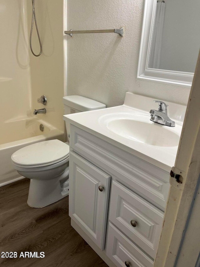 full bathroom with shower / bathing tub combination, vanity, hardwood / wood-style flooring, and toilet