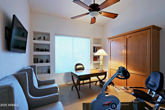 carpeted office space with ceiling fan and built in features