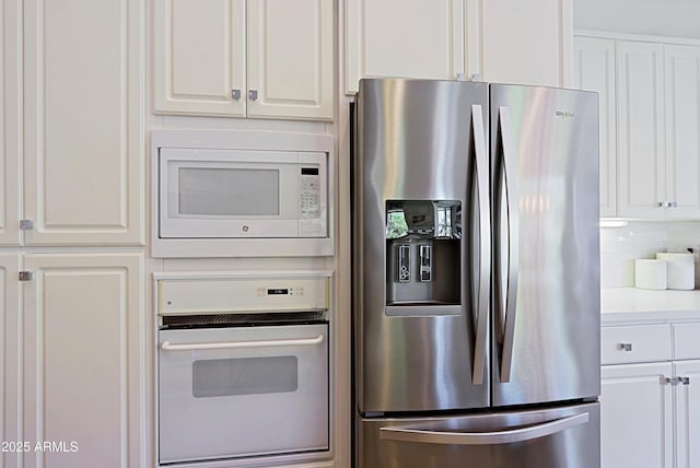 kitchen with white cabinetry, white appliances, and backsplash