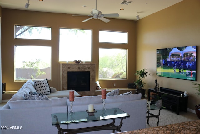 living room featuring ceiling fan and a high end fireplace