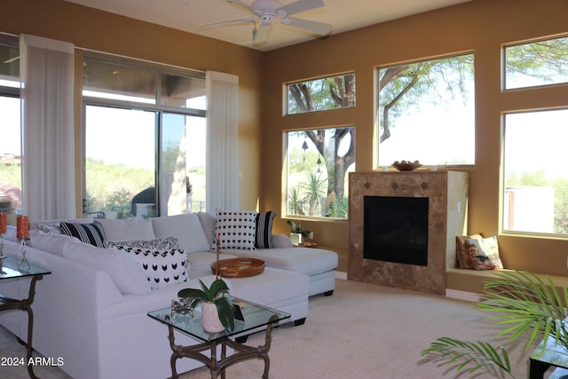 carpeted living room with ceiling fan and a high end fireplace