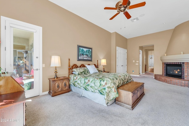 bedroom featuring ceiling fan, light colored carpet, and a brick fireplace