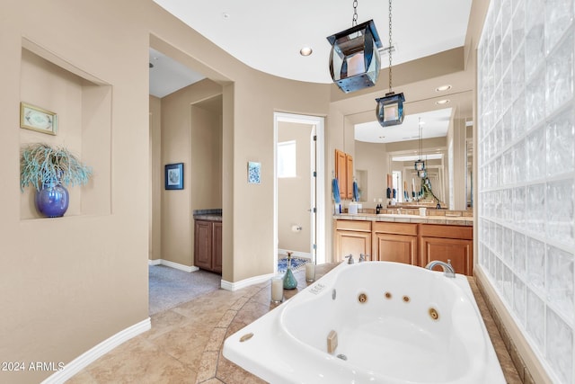 bathroom with vanity, tile patterned flooring, and a relaxing tiled tub