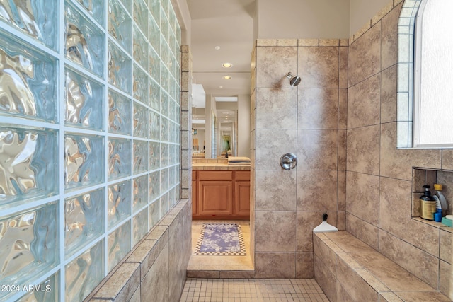 bathroom featuring walk in shower, vanity, tile walls, and tile patterned floors