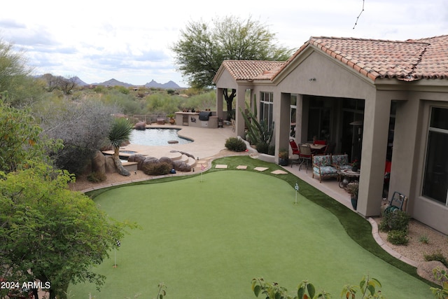 view of yard with a mountain view, a patio area, an outdoor living space, and exterior kitchen