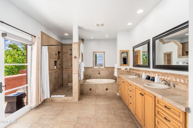 bathroom featuring plus walk in shower, tile patterned flooring, and vanity