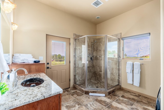 bathroom with a shower with shower door, tile patterned flooring, and vanity