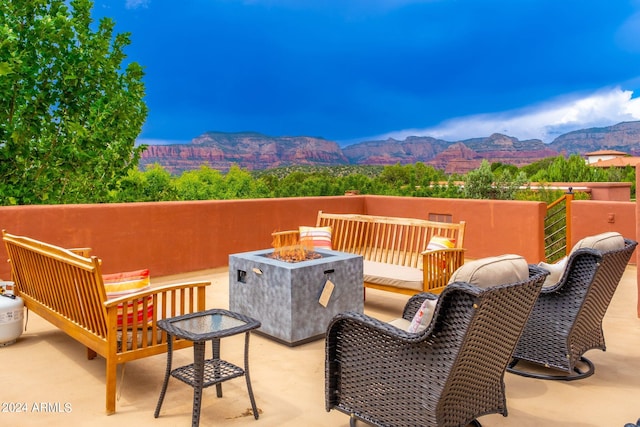 view of patio / terrace featuring a mountain view and an outdoor living space with a fire pit