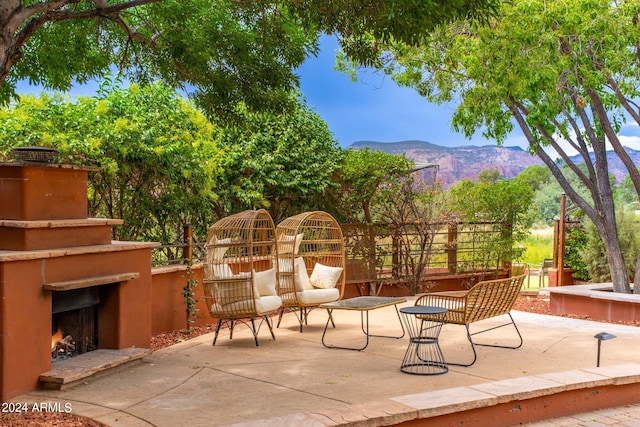 view of patio featuring a mountain view and an outdoor fireplace