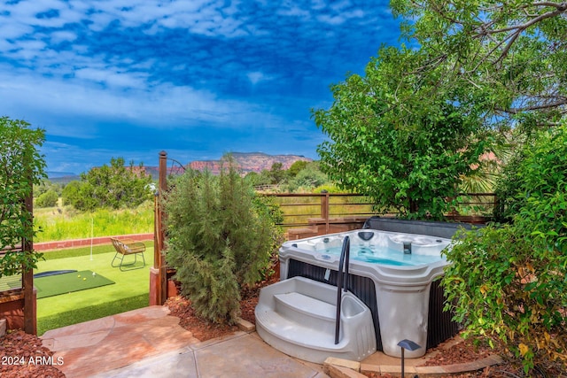 view of patio featuring a hot tub and a mountain view