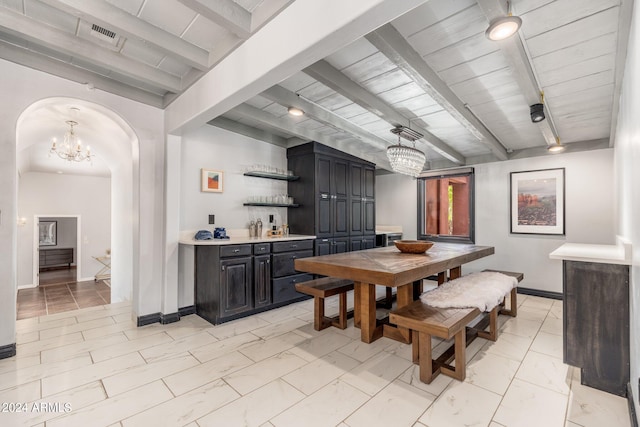 dining room with light tile patterned flooring, beam ceiling, and a notable chandelier