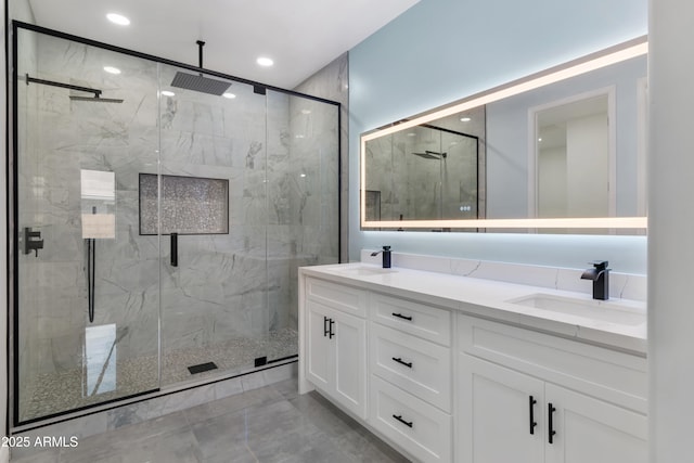 bathroom featuring double vanity, a sink, a marble finish shower, and recessed lighting