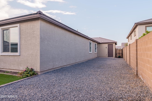 view of property exterior featuring fence and stucco siding