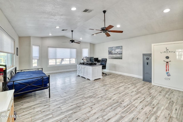 living room featuring a textured ceiling, ceiling fan, light hardwood / wood-style floors, and vaulted ceiling