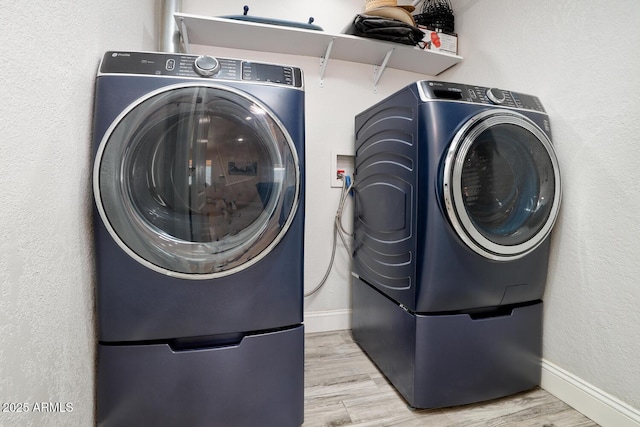 laundry area featuring light wood-type flooring and washer / clothes dryer