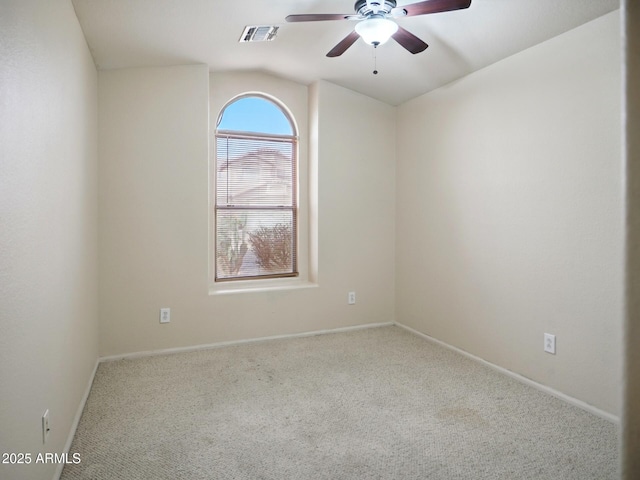 spare room featuring carpet floors, a ceiling fan, lofted ceiling, and baseboards