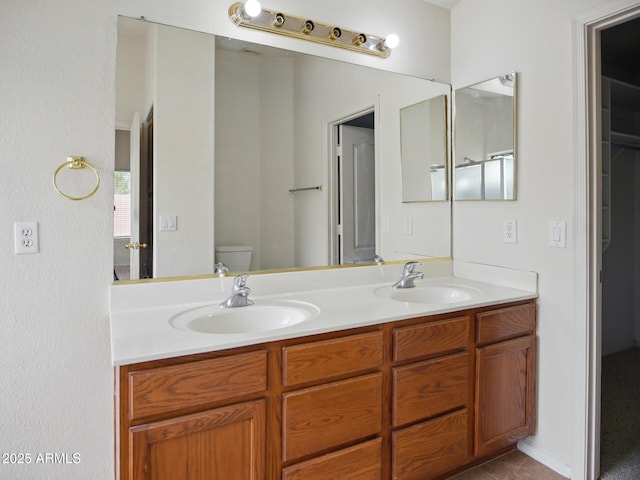 full bath with toilet and double vanity