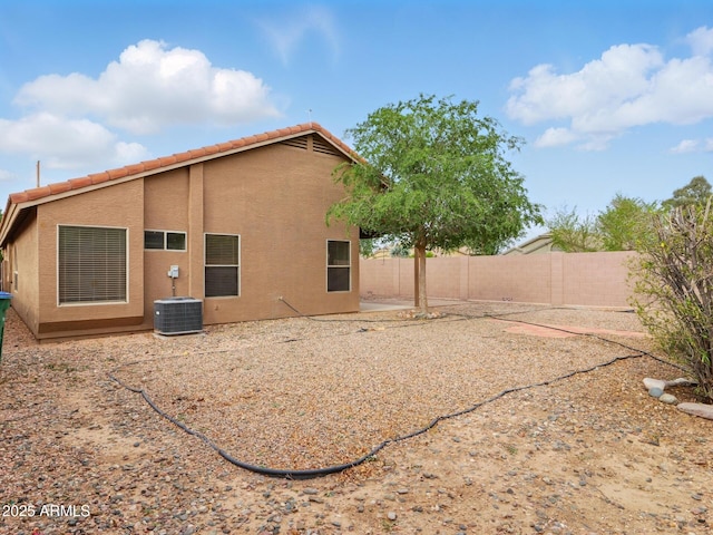 back of house with a fenced backyard, stucco siding, a tile roof, and cooling unit