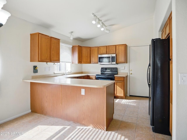 kitchen featuring black appliances, vaulted ceiling, a peninsula, rail lighting, and light countertops