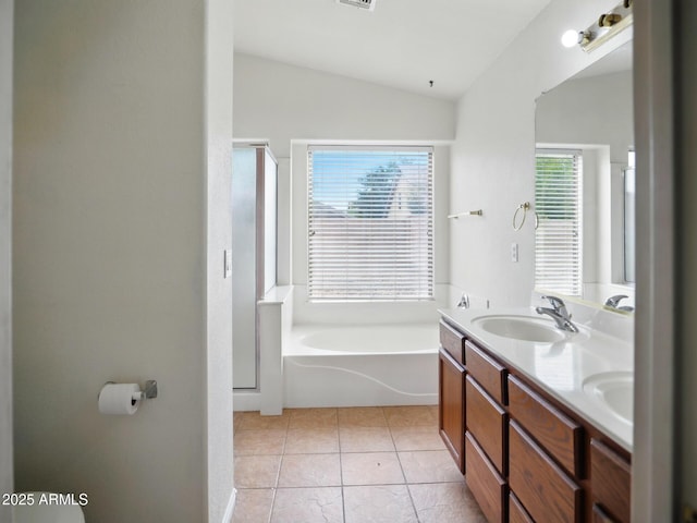 bathroom featuring lofted ceiling, plenty of natural light, a shower stall, double vanity, and a garden tub