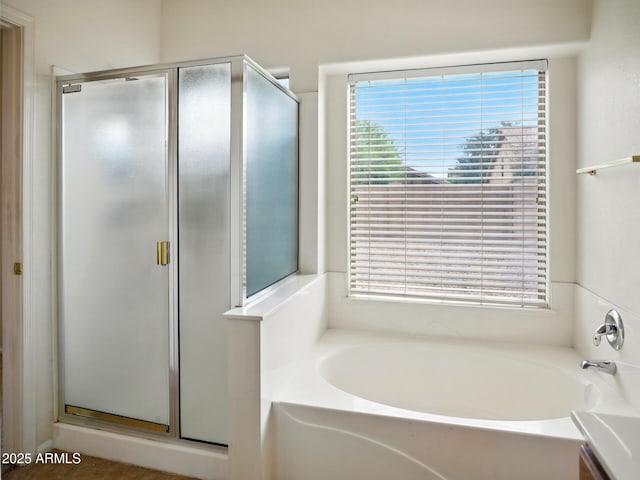 full bath featuring a stall shower, a garden tub, and plenty of natural light