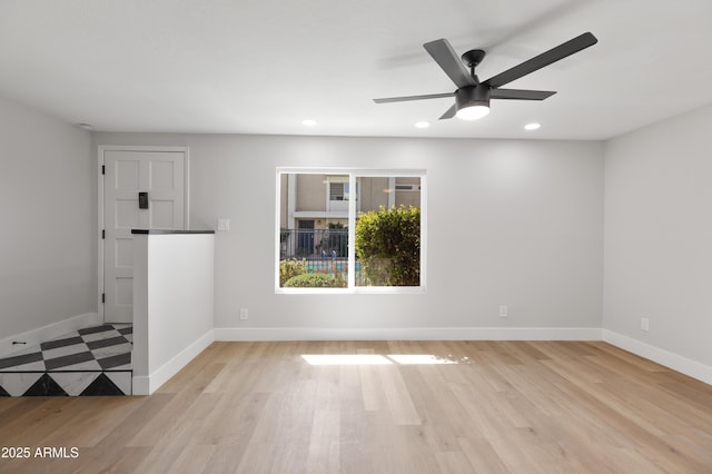 spare room with recessed lighting, light wood-type flooring, baseboards, and a ceiling fan