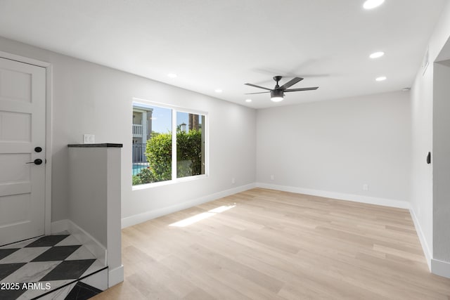 spare room with recessed lighting, light wood-type flooring, baseboards, and a ceiling fan