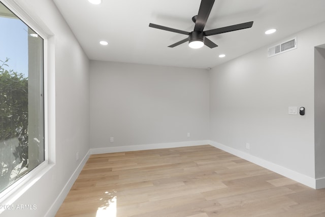 unfurnished room with visible vents, a healthy amount of sunlight, and light wood-type flooring