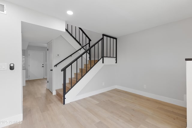 stairway featuring visible vents, recessed lighting, baseboards, and wood finished floors