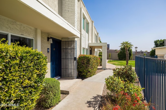 entrance to property with fence and stucco siding