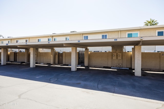 covered parking lot featuring fence