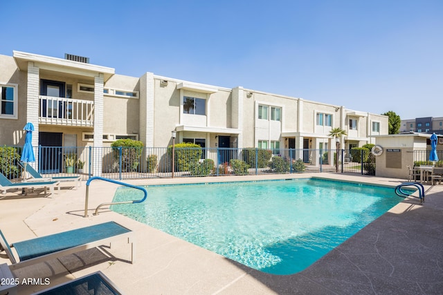 pool featuring a patio area, fence, and a residential view