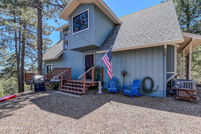 rear view of house featuring central AC, a shingled roof, and a wooden deck