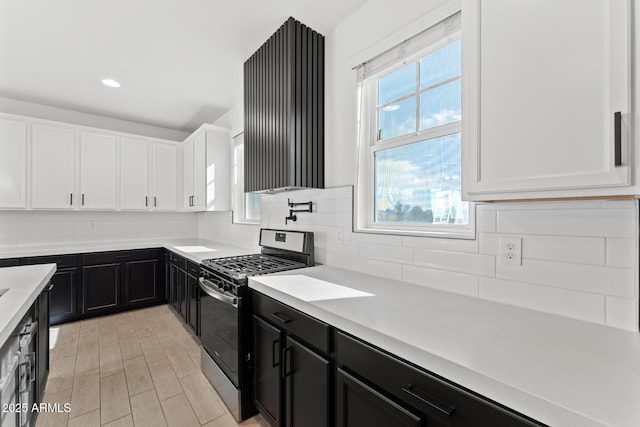 kitchen with white cabinetry, light hardwood / wood-style flooring, tasteful backsplash, and stainless steel gas range oven