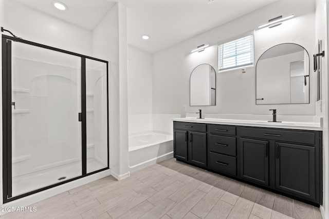 bathroom with hardwood / wood-style flooring, vanity, and separate shower and tub