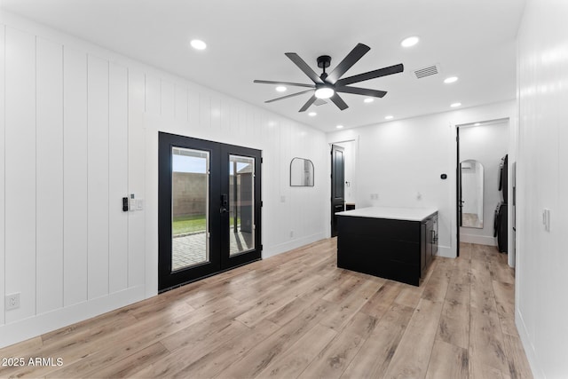 interior space with light hardwood / wood-style flooring, french doors, ceiling fan, and a kitchen island