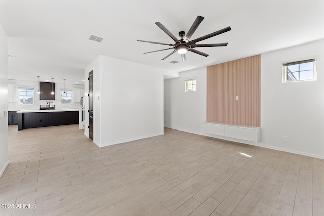 unfurnished living room featuring ceiling fan and light wood-type flooring