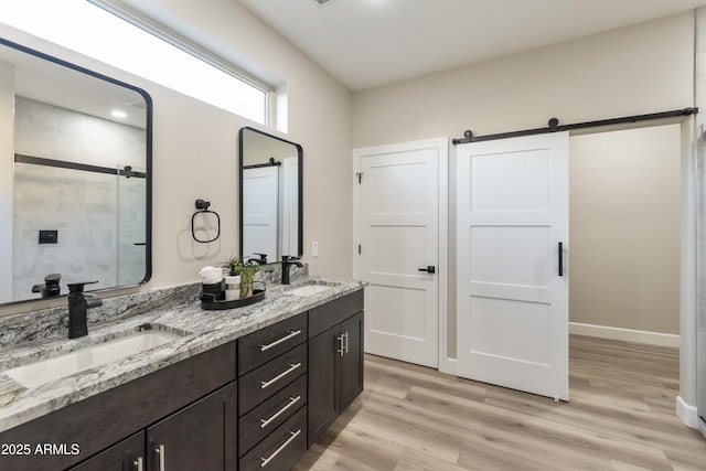 bathroom featuring walk in shower, vanity, and hardwood / wood-style flooring