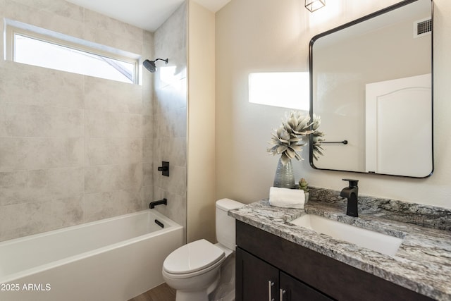 full bathroom featuring toilet, tiled shower / bath, and vanity