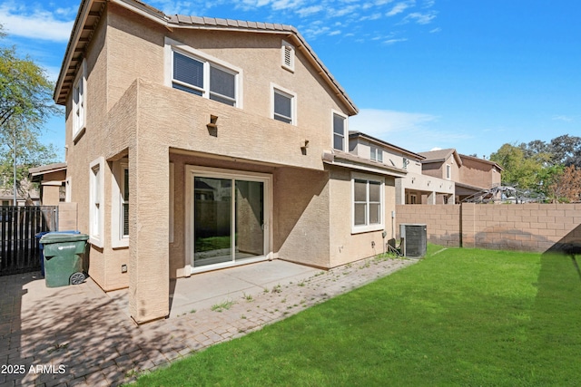 back of property featuring central AC unit, a yard, a fenced backyard, stucco siding, and a patio area