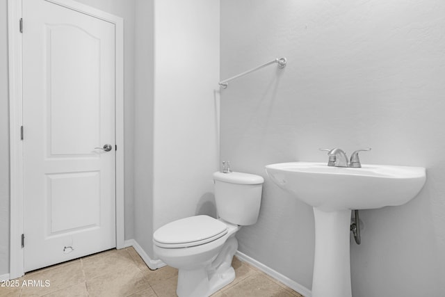 bathroom with tile patterned floors, toilet, and baseboards